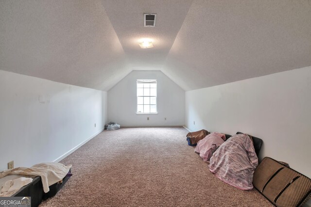 bonus room with lofted ceiling, carpet floors, a textured ceiling, and baseboards