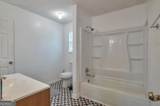 bathroom featuring toilet, baseboards, washtub / shower combination, tile patterned flooring, and vanity