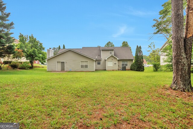 rear view of house featuring a lawn