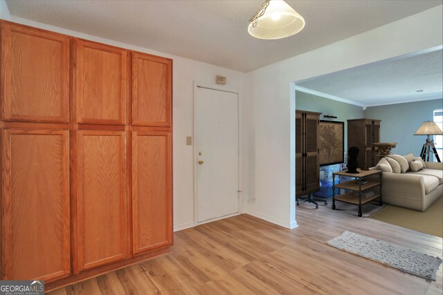 bedroom with light wood-style floors, a desk, ornamental molding, and baseboards