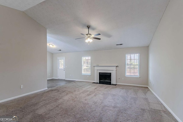 1363 To Lani Farm Rd, Stone Mountain, GA 30083 - unfurnished living room featuring carpet, ceiling fan, baseboards, a fireplace with flush hearth, and a textured ceiling