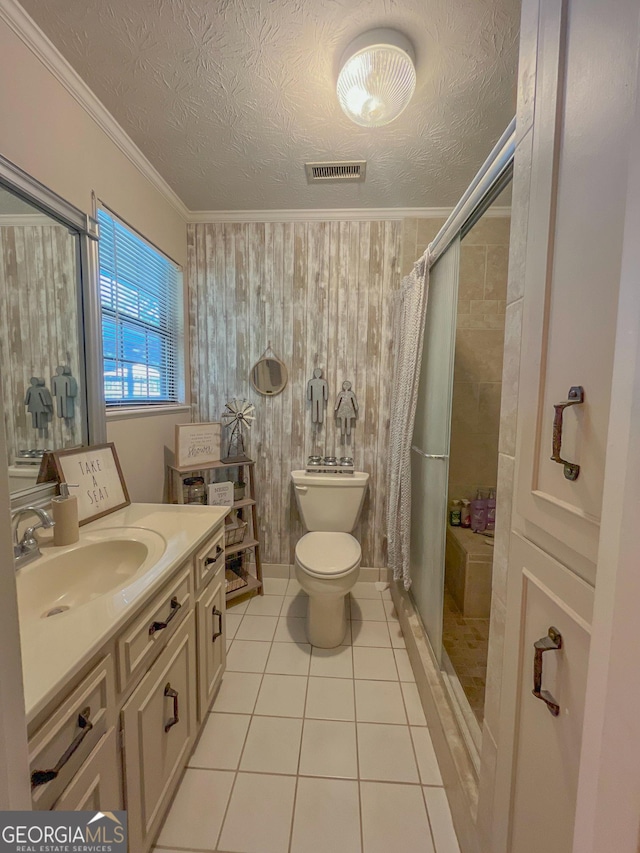 bathroom with tiled shower, toilet, tile patterned flooring, vanity, and a textured ceiling