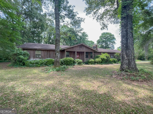 ranch-style house with a front lawn and a chimney