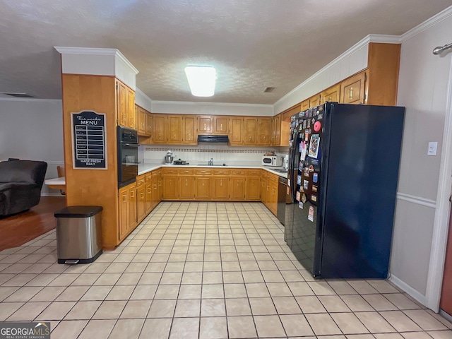 kitchen featuring black appliances, light countertops, crown molding, under cabinet range hood, and light tile patterned floors