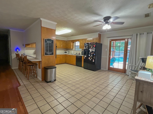 kitchen featuring black appliances, light countertops, ceiling fan, light tile patterned floors, and crown molding