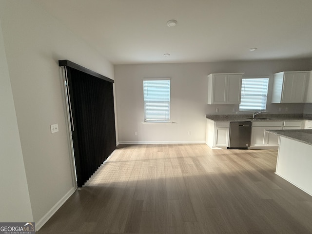 2051 Blue Sky Ave, Covington, GA 30016 - kitchen featuring dishwasher, a sink, healthy amount of natural light, and white cabinetry