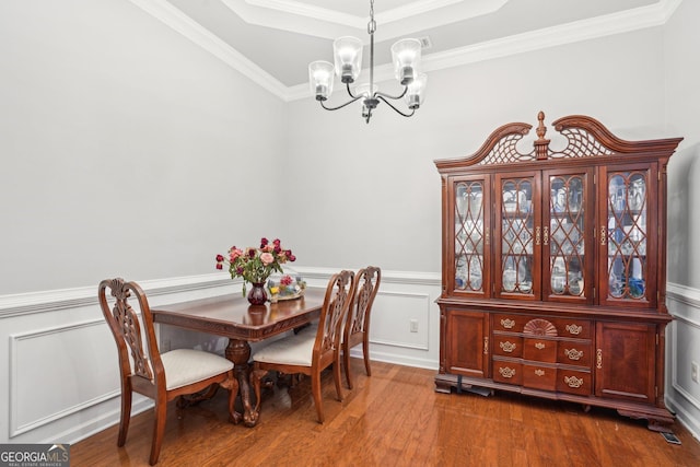 1010 Capella Creek Way, Grayson, GA 30017 - dining area featuring a chandelier, crown molding, dark wood finished floors, a tray ceiling, and a wainscoted wall