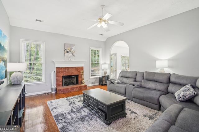 1010 Capella Creek Way, Grayson, GA 30017 - living room featuring wood finished floors, arched walkways, baseboards, a brick fireplace, and ceiling fan