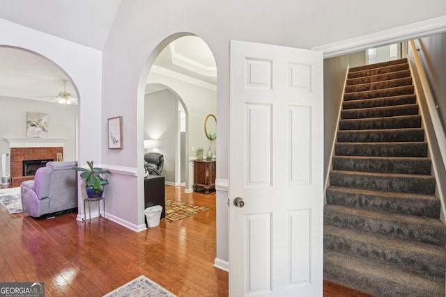 1010 Capella Creek Way, Grayson, GA 30017 - stairs featuring ceiling fan, hardwood / wood-style floors, baseboards, a fireplace, and arched walkways