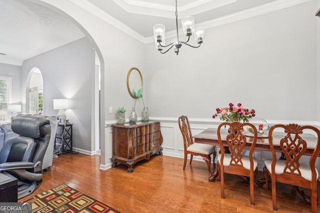 1010 Capella Creek Way, Grayson, GA 30017 - dining area featuring arched walkways, hardwood / wood-style flooring, a chandelier, crown molding, and a wainscoted wall