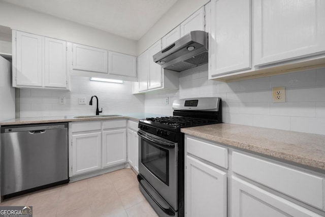 kitchen with stainless steel appliances, under cabinet range hood, a sink, and white cabinets