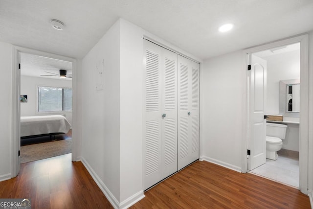 corridor with wood finished floors and baseboards