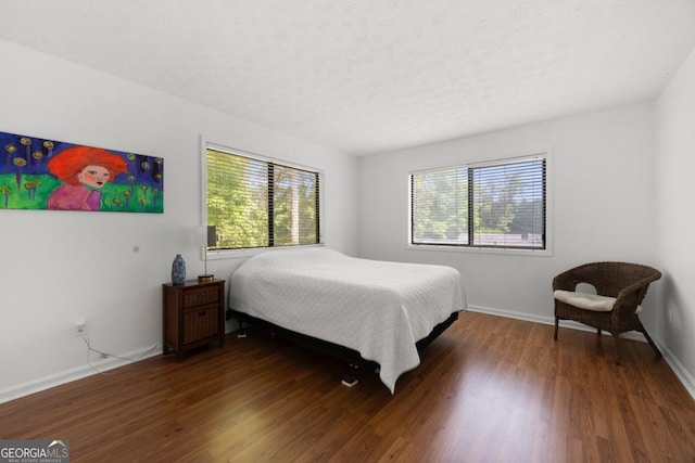 bedroom featuring multiple windows, wood finished floors, and baseboards