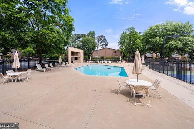 community pool featuring fence and a patio