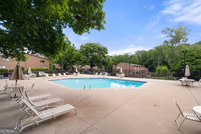 community pool featuring fence and a patio