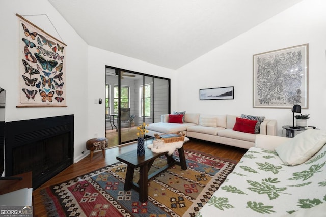 living room featuring a fireplace, dark wood-type flooring, and high vaulted ceiling