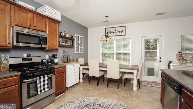 kitchen with appliances with stainless steel finishes, a chandelier, brown cabinetry, dark countertops, and open shelves