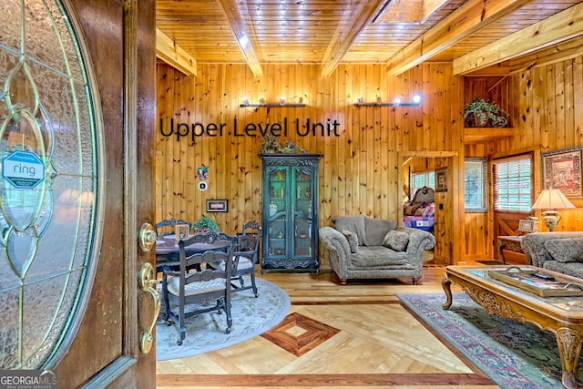 living room with wood ceiling, beamed ceiling, wood walls, and wood finished floors