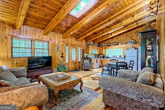 living area featuring plenty of natural light, a skylight, wood ceiling, wood walls, and light wood finished floors