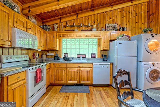 kitchen featuring white appliances, estacked washer and dryer, wooden ceiling, light wood-type flooring, and a sink