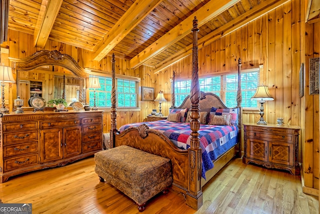 bedroom with beam ceiling, light wood-style floors, wooden ceiling, and wood walls