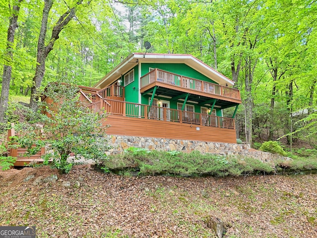chalet / cabin featuring a deck and a view of trees
