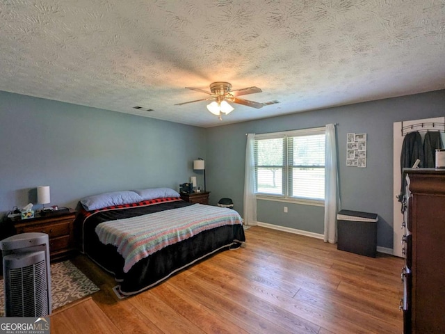 2003 Brenda Ln, Vidalia, GA 30474 - bedroom featuring wood finished floors, a textured ceiling, baseboards, and a ceiling fan
