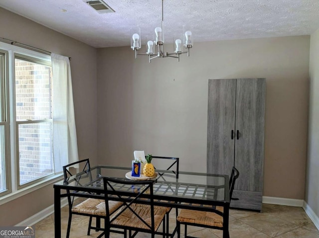 2003 Brenda Ln, Vidalia, GA 30474 - dining room with a chandelier, healthy amount of natural light, a textured ceiling, and light tile patterned floors