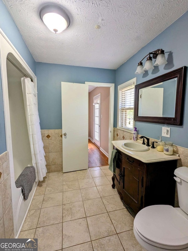 2003 Brenda Ln, Vidalia, GA 30474 - full bathroom featuring toilet, a textured ceiling, tile patterned floors, vanity, and a shower with shower curtain