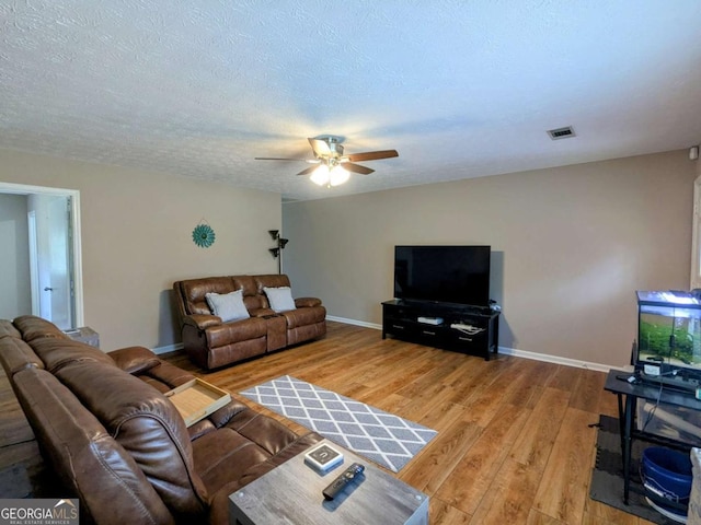 2003 Brenda Ln, Vidalia, GA 30474 - living area featuring light wood-style floors, a ceiling fan, baseboards, and a textured ceiling
