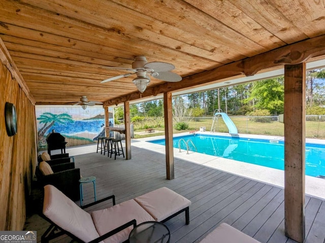 2003 Brenda Ln, Vidalia, GA 30474 - outdoor pool with a water slide, ceiling fan, a fenced backyard, and a wooden deck