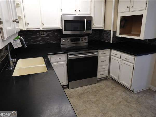 410 Live Oak Church Rd, Hinesville, GA 31313 - kitchen with appliances with stainless steel finishes, white cabinets, and dark countertops