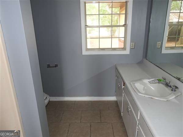 410 Live Oak Church Rd, Hinesville, GA 31313 - bathroom featuring tile patterned flooring, vanity, baseboards, and toilet