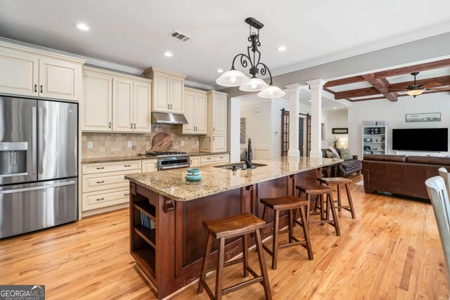 kitchen featuring appliances with stainless steel finishes, a sink, cream cabinets, under cabinet range hood, and coffered ceiling
