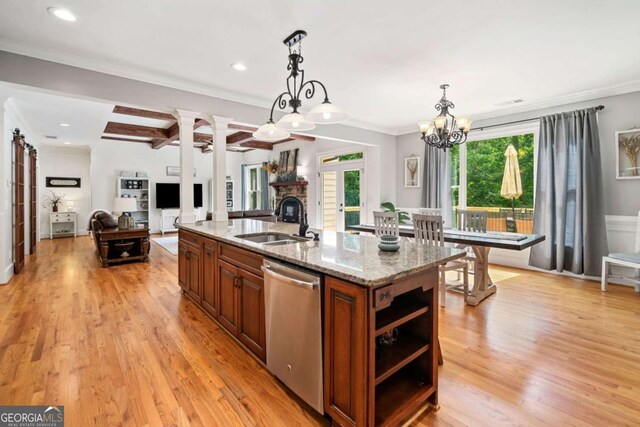 kitchen featuring a sink, stainless steel dishwasher, brown cabinetry, a center island with sink, and open shelves