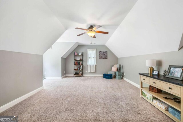 rec room featuring carpet floors, baseboards, vaulted ceiling, and ceiling fan