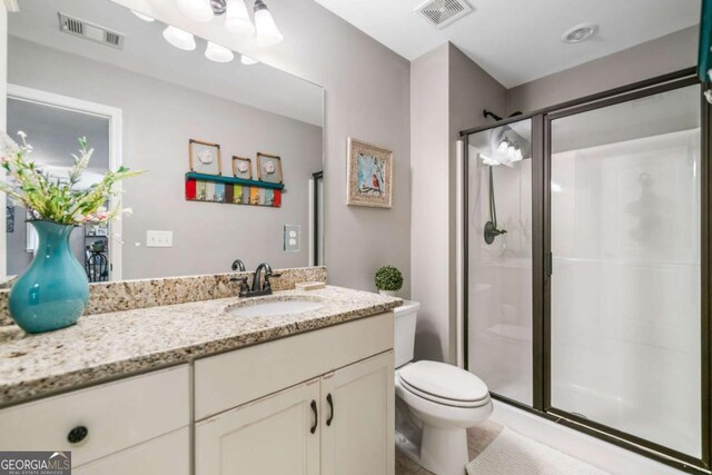bathroom with a stall shower, toilet, and vanity