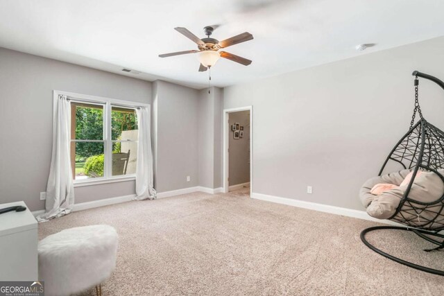 sitting room with carpet, ceiling fan, and baseboards