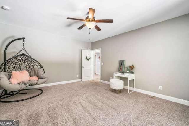 living area featuring ceiling fan, carpet, and baseboards