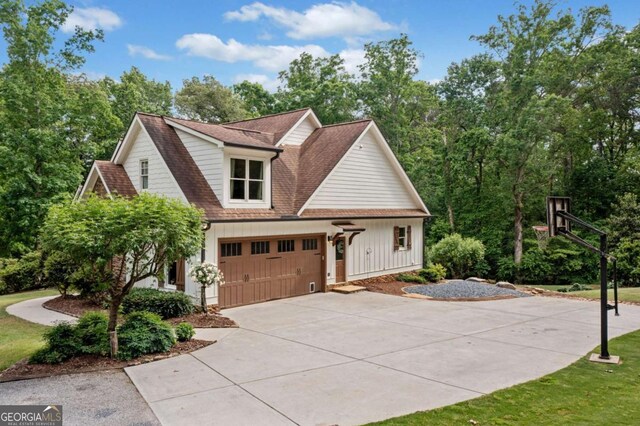 view of home's exterior featuring driveway, board and batten siding, roof with shingles, and a garage