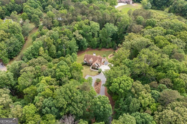 aerial view of property and surrounding area with a heavily wooded area