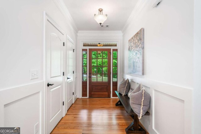 foyer entrance featuring ornamental molding and light wood finished floors