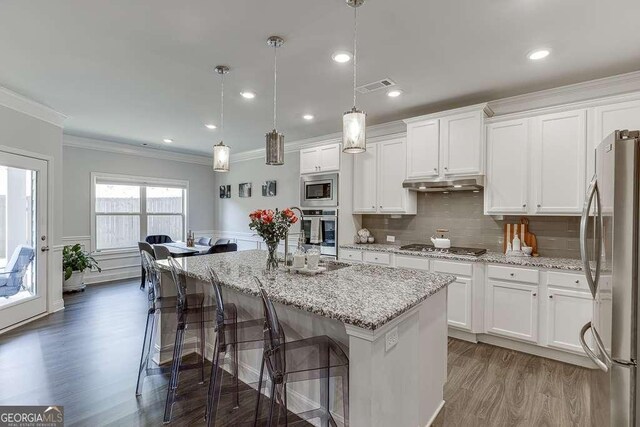 7016 Lancaster Xing, Flowery Branch, GA 30542 - kitchen with stainless steel appliances, crown molding, wood finished floors, under cabinet range hood, and white cabinets