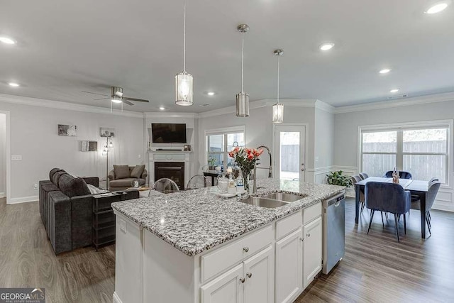 kitchen with a sink, ceiling fan, dark wood finished floors, ornamental molding, and stainless steel dishwasher