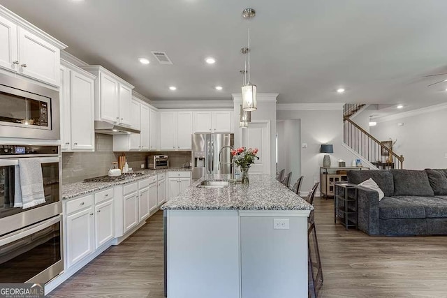kitchen featuring a sink, stainless steel appliances, crown molding, white cabinetry, and dark wood-style flooring