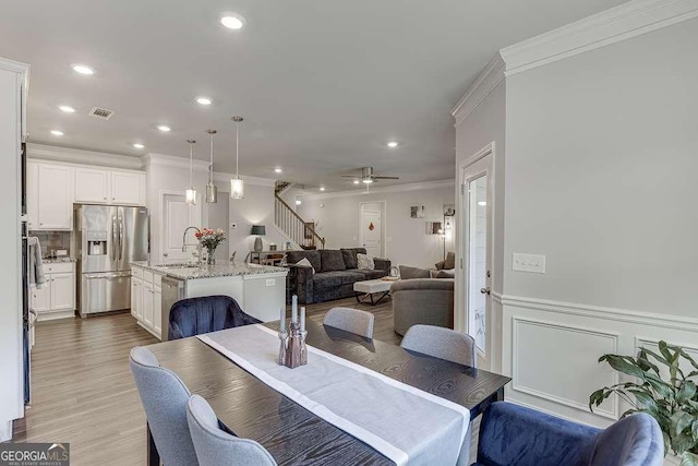 dining room with crown molding, a ceiling fan, stairway, wood finished floors, and recessed lighting