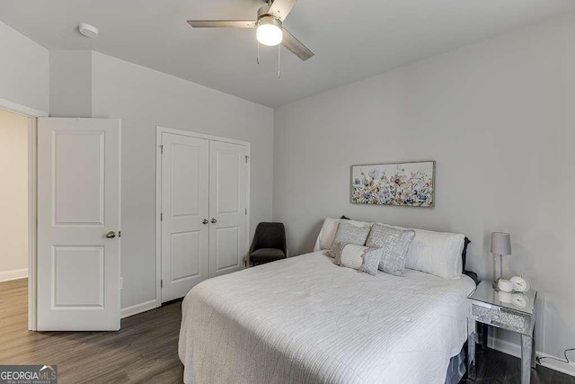 bedroom with dark wood-style flooring, a closet, a ceiling fan, and baseboards