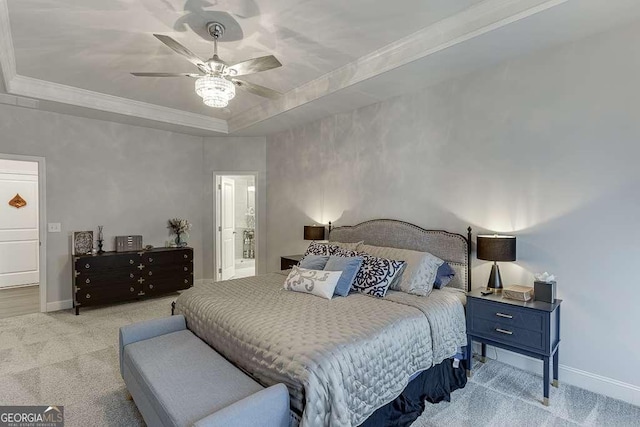 carpeted bedroom featuring baseboards, a raised ceiling, crown molding, and a ceiling fan