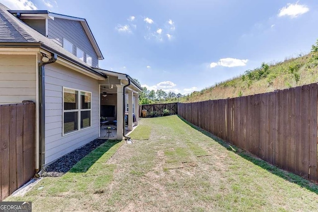 view of yard featuring a ceiling fan and a patio area