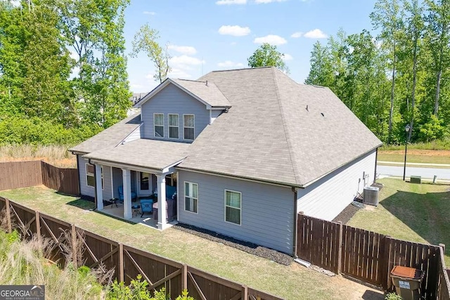 back of property featuring central AC, a patio, and roof with shingles